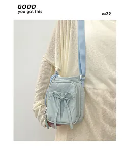 Détail de la bandoulière en nylon bleu clair avec décoration en nœud et sangle réglable