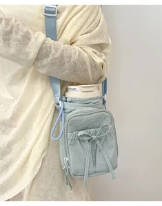 Gros plan du sac bandoulière vert menthe avec poche à nœud et compartiment gourde
