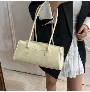 Close-up of cream-colored rectangular shoulder bag with FASHION & BAGS LEATHER print details