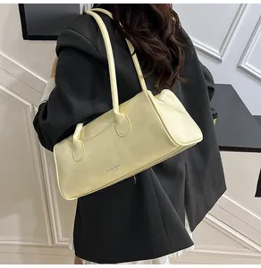 Detail view of cream leather shoulder bag with FASHION & BAGS logo on grey suit