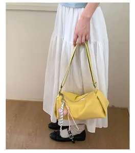 Close-up of lemon yellow nylon crossbody bag featuring cute heart charms and zipper detail