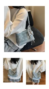Detail view of denim handbag featuring intricate jacquard patterns and metallic star charms