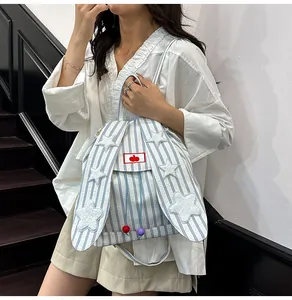 Detail of blue striped canvas backpack with rabbit ears and white star appliqués