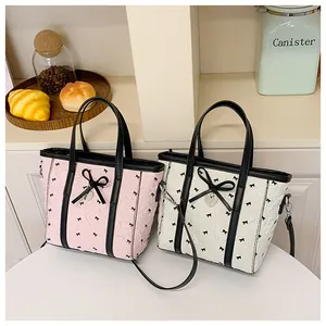 Détail de sacs fourre-tout à nœuds roses et blancs avec charms cœur et PU texturé de qualité