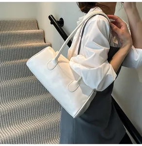 Detail of white rectangular shoulder bag in glossy leather featuring twin strap design