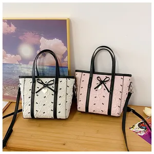 Détail du sac cabas en tissu bulle avec motifs nœuds et breloque cœur doré