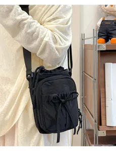 Détail d'un sac bandoulière noir en nylon avec cordon nœud et sangle réglable