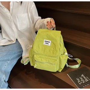 Detail of light green nylon backpack with pleated texture and drawstring side pockets