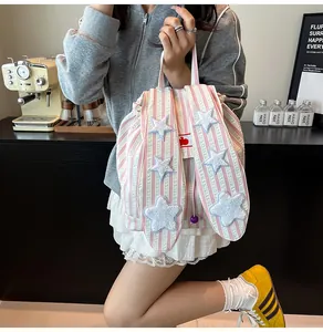 Detail view of rabbit ears and star embroidery on a pink striped canvas backpack