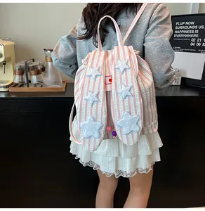 Detail of pink striped backpack with decorative rabbit ears and small star patches