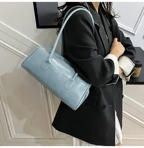 Close-up of light blue patent leather shoulder bag with glossy finish and strap detail