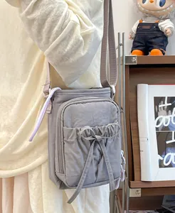 Vue latérale d'un sac bandoulière en nylon lilas avec nœud à cordon et fermeture