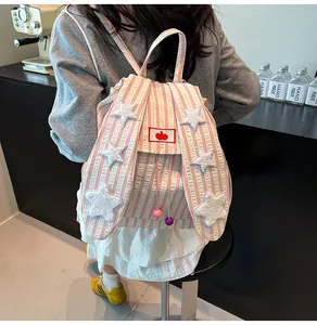 Detail of pink striped backpack with bunny ears and white plush star patches for students