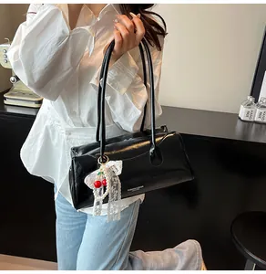 Chic black Boston handbag with cherry pendant and pearl lace charm detail