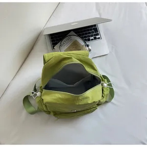 Close-up of green nylon backpack interior with compartments and smooth main zipper