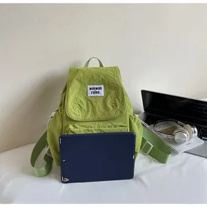 Light green nylon backpack shown with a tablet to demonstrate interior storage capacity