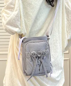 Vue arrière d'un sac bandoulière en nylon souple avec nœud et bandoulière réglable