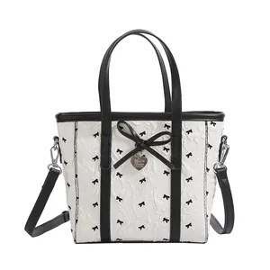 Sac seau blanc avec motifs nœuds noirs et pendentif en métal en forme de cœur