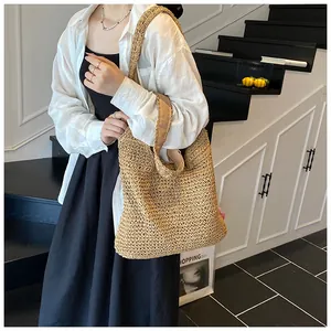 Detailed view of handmade woven straw tote bag texture and soft brown fabric straps