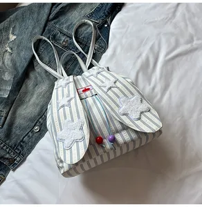 Detailed close-up of blue striped backpack with cute rabbit ears and plush stars