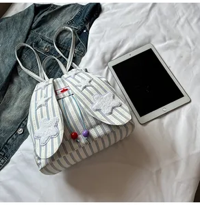 Detail of blue striped backpack with cute rabbit ears and soft white star embroidery