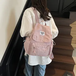 Pink minimalist nylon backpack with flap closure and adjustable side drawstrings