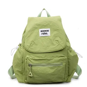 Minimalist avocado green nylon backpack for women with drawstring side pockets and top flap