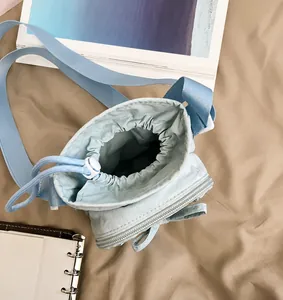 Vista superior que muestra la gran capacidad y el cierre de cordón de este bolso bandolera
