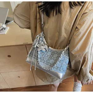 Detail of blue denim crossbody bag with sparkling rhinestones and silver chain strap