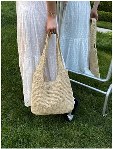 Detailed view of woven straw tote bag texture and durable fabric lining on the grass
