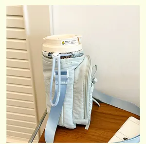 Détail du sac bandoulière bleu clair à cordon avec poche zippée et sangle réglable