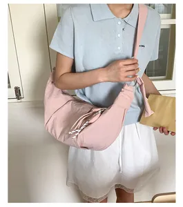 Detailaufnahme der rosa Halbmond-Umhängetasche mit gewebtem Kordelzug und Gurt
