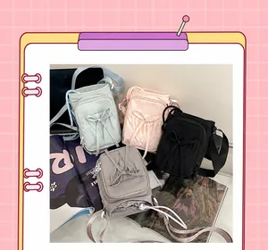 Detalle de minibolsos bandolera de colores con lazos decorativos y correas anchas ajustables