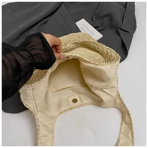 Detail of hand-woven straw tote featuring fabric lining and secure magnetic metal closure