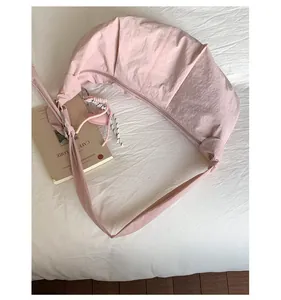 Rosafarbene Nylon-Mondtasche mit Herzanhänger und geflochtenen Details auf Stoff