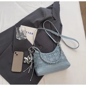 Detail of blue denim hobo bag with sparkling rhinestones, silver chain, and heart charms