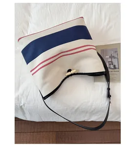 Detail of canvas beach tote showing nautical stripes and toggle closure detail
