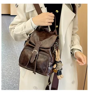 Detailansicht des braunen Kunstleder-Rucksacks mit Hasen-Anhänger und Metallschnallen