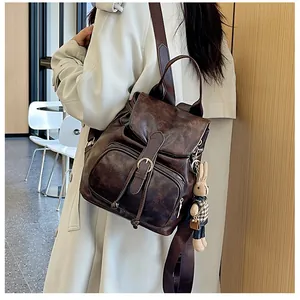 Detail eines Vintage braunen Kunstlederrucksacks mit Klappe und niedlichem Hasenanhänger