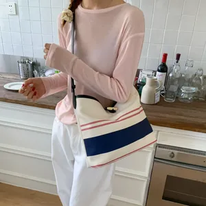 Chic striped canvas bucket bag for women with minimalist navy and red accents