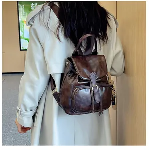 Detail eines dunkelbraunen Vintage-Rucksacks aus Kunstleder mit Hasen-Anhänger und Klappe