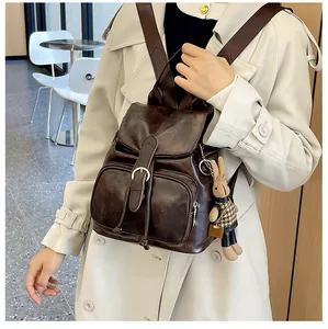 Detailansicht des braunen Kunstleder-Rucksacks mit Klappverschluss und süßem Hasen-Anhänger