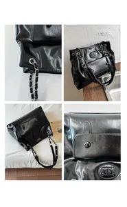 Detail of glossy black leather tote bag with metal chain strap and front flap pocket