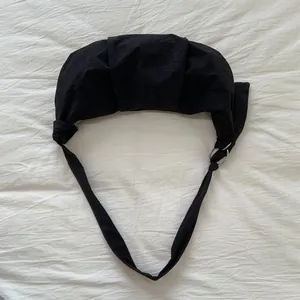 Nahaufnahme der schwarzen Nylon-Croissant-Tasche mit Falten und silbernem Ring