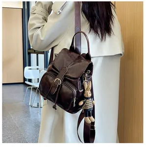 Detailansicht eines dunkelbraunen Vintage-Rucksacks mit Plüschhasen-Anhänger