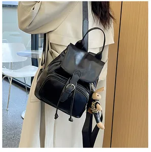 Detail eines schwarzen glänzenden Rucksacks mit Kordelzug und weichem Hasen-Anhänger