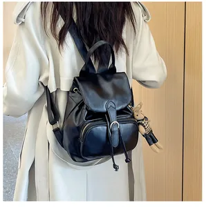 Details eines schwarzen Kunstlederrucksacks mit Kordelzug und weichem Hasenanhänger