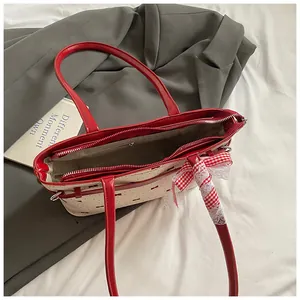 Vue détaillée du sac à main rouge et blanc avec ruban et dentelle sur tissu
