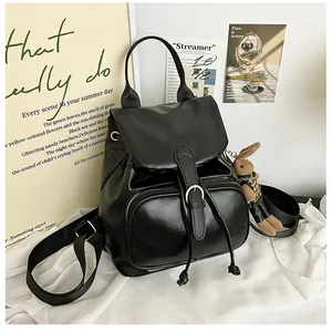 Detail eines schwarzen PU-Lederrucksacks mit Reißverschlusstasche und süßem Hasenanhänger