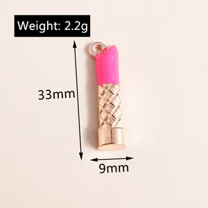 Dettaglio di ciondolo a rossetto con smalto rosa brillante e trama a rombi dorati